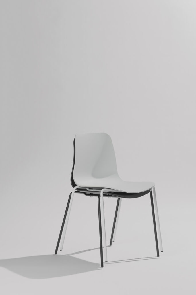 Twee Curvo stoelen gestapeld op elkaar in een stijlvolle fotostudio met neutrale achtergrond en zachte belichting, waarbij het moderne design en de efficiënte stapelbaarheid centraal staan.