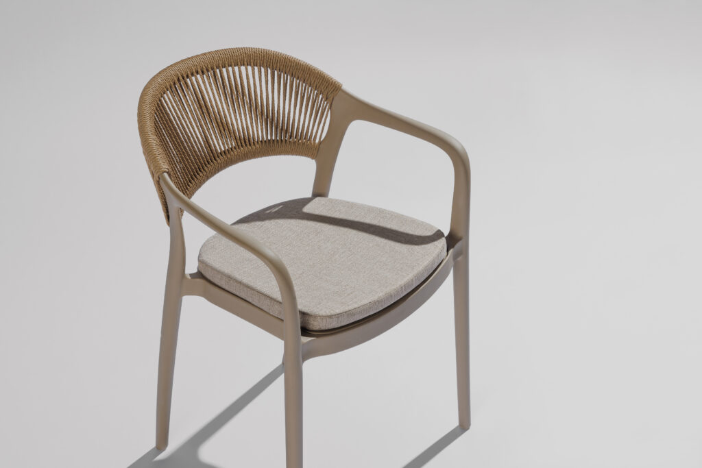 Hellen stoel in een stijlvolle fotostudio met neutrale achtergrond en zachte belichting, waarbij het elegante design, de verfijnde lijnen en de hoogwaardige afwerking centraal staan.