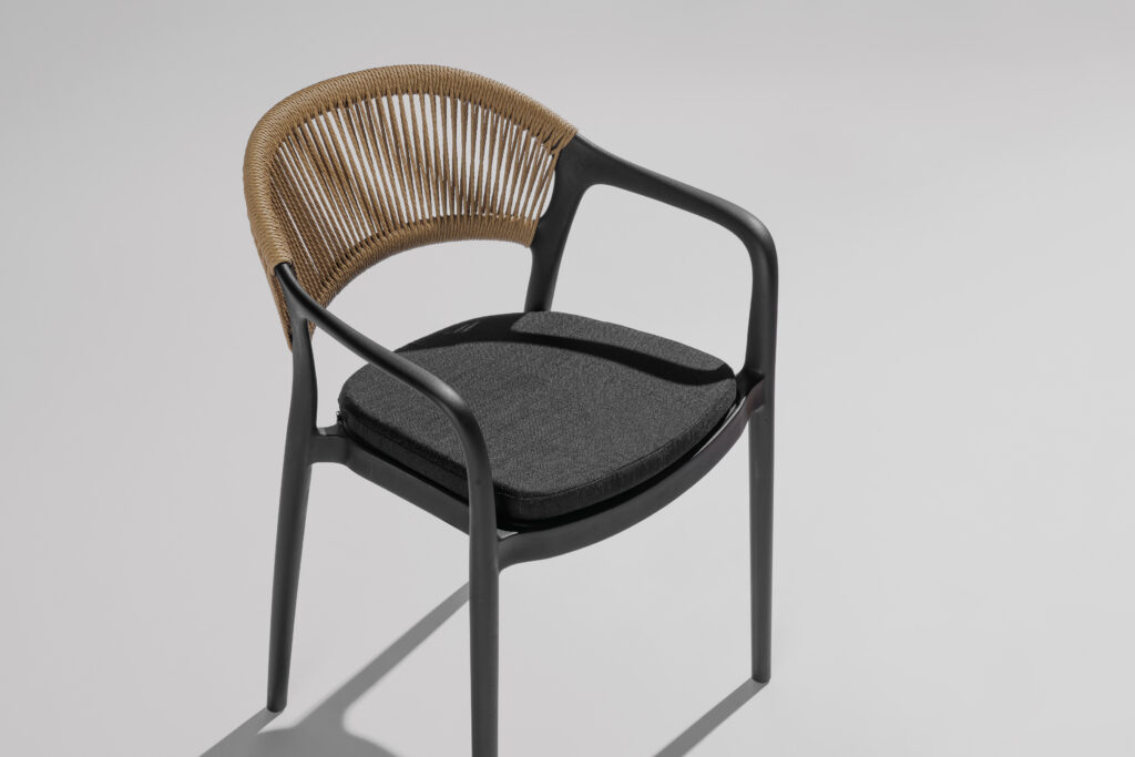 Hellen stoel in een stijlvolle fotostudio met neutrale achtergrond en zachte belichting, waarbij het elegante design, de verfijnde lijnen en de hoogwaardige afwerking centraal staan.