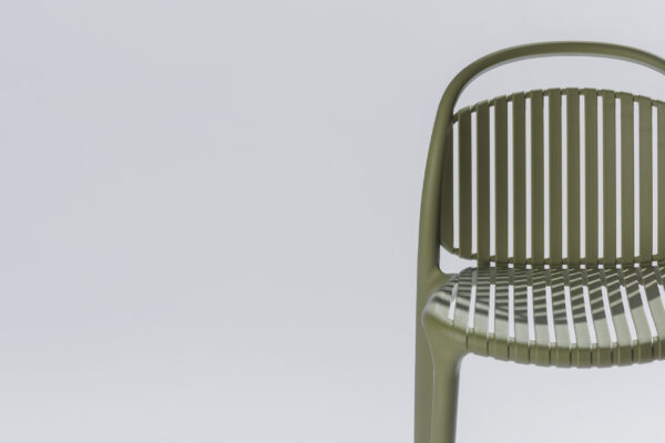 Detail image of the green Strato chair in a stylish photo studio with a neutral background and soft lighting, where the refined finish, clean lines, and modern design take center stage.