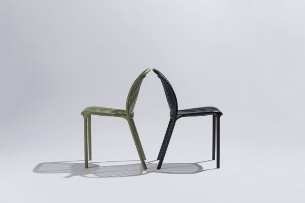 Green and black Strato chairs arranged together in a stylish photo studio with a neutral background and soft lighting, where the modern design and the contrast between the colors take center stage.