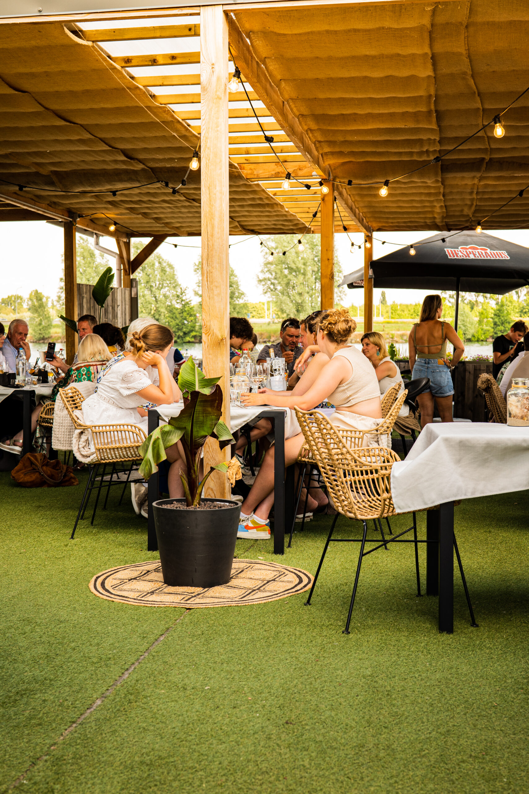 Terras- en patio meubilair met Palm arm chair in een gezellige buitenruimte waar buiten het nieuwe binnen wordt.