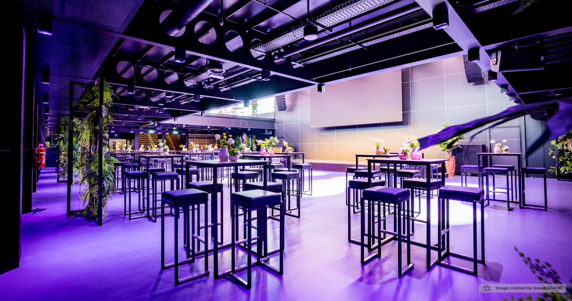 Zwarte Kubo collectie met statafels en barkrukken in een moderne eventlocatie met sfeervolle verlichting en professionele opstelling