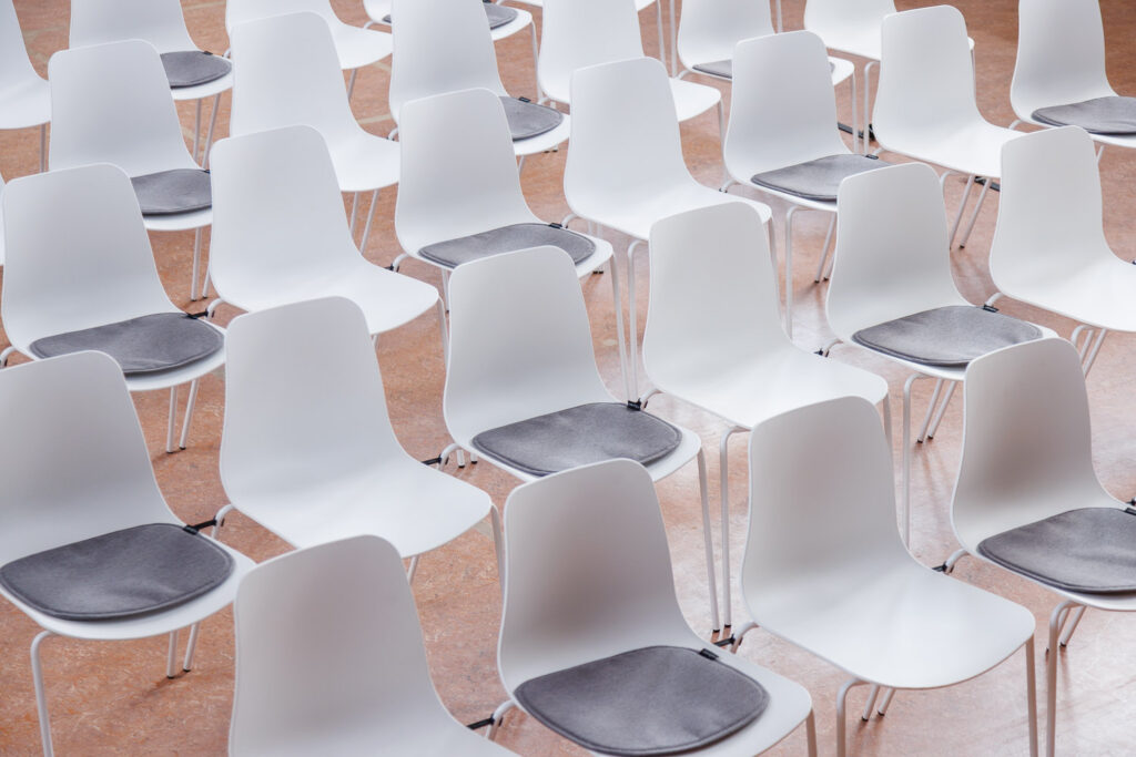 Witte Curvo stoelen in theateropstelling, licht en strak opgesteld voor presentaties, seminars en conferenties