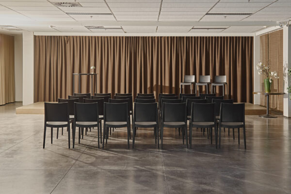 Seminarieruimte waar June stoelen op een rij staan en Kasar barstoelen op het podium samen met een Kubo Party tafel